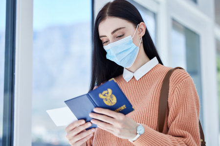 Passport, id and travel woman with covid face mask for immigration, airport compliance and vacation information security. Covid 19, corona virus and girl with identity document and ticket for flightの写真素材