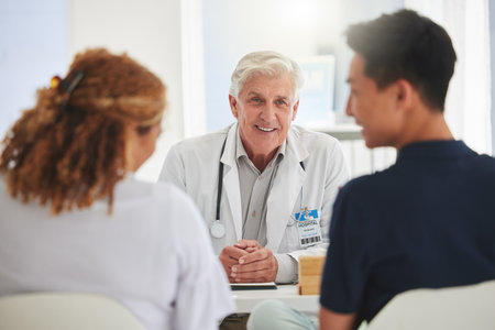 His job brings him joy. a mature doctor having a checkup with a patient at a hospital.の写真素材