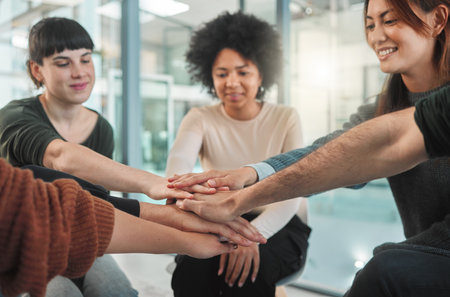 Happiness begins here. people stacking their hands during a group therapy session.の写真素材