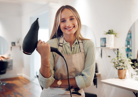 Beauty salon, hairdresser woman and portrait with hair dryer tools, retail barber shop boutique and hair care stylist ready for blow dry treatment service. Happy young hair salon small business ownerの写真素材