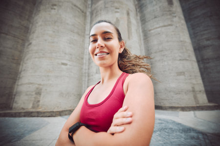 Fitness is the life I choose. Cropped portrait of an attractive young female athlete standing with her arms folded while running outdoors.の写真素材