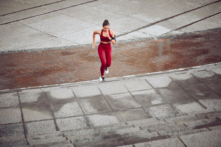 Move like you mean it. High angle shot of an attractive young female athlete running outdoors.の写真素材