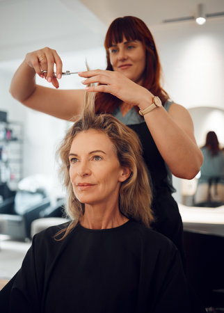 Woman, hair and salon for haircut with hairdresser for beauty, style or makeover. Customer, beautician and cosmetics for professional hair care, service or fashion in studio, spa or shop in Torontoの写真素材