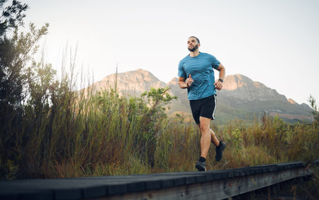 Runner, fitness and man in nature running for outdoor workout, healthy energy and wellness goal with...