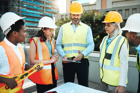 Ive got the clients plans right here. a diverse group of contractors standing outside together and having a discussion over building plans.の写真素材