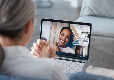 I caught myself mid-trigger yesterday. an unrecognisable psychologist sitting and using a laptop for an online consultation with her patient.の写真素材