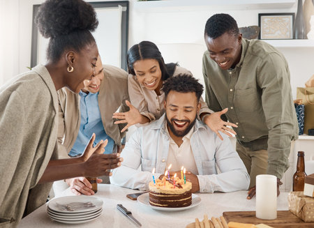 Hes so surprised. a young man celebrating his birthday with friends at home.