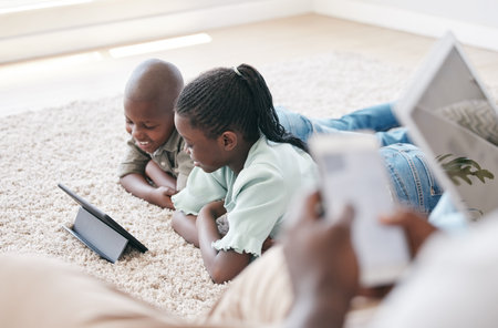 The memories we make with our family is everything. a brother and sister using a tablet at home.の写真素材