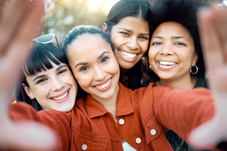 Spend a lot of time with them. a group of female friends taking a selfie in a park.の写真素材