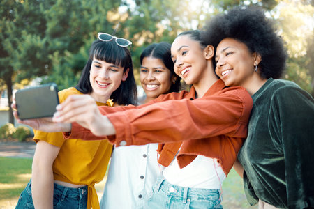 A friend accepts you just the way you are. a group of female friends taking a selfie in a park.の写真素材