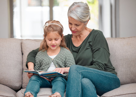 She gets her love for books from me. a grandmother and granddaughter bonding on the sofa while using a digital tablet.の写真素材