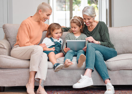 No room for negativity. a mature woman bonding with her daughter and grandkids while using a digital tablet.の写真素材