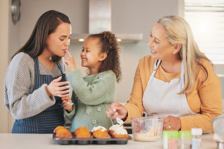 Youre so sweet. a little girl baking with her mother and grandmother at home.の写真素材