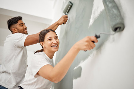 We just moved in and already renovating. a young couple painting a room together.の写真素材