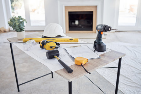 Ready to design your home. building plans and equipment on a table in an empty living room during the day.の写真素材