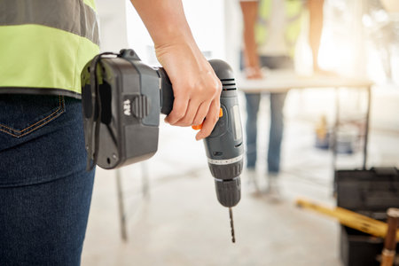 Time to add those personal touches. an unrecognisable construction worker standing in a house and holding a power drill.の写真素材