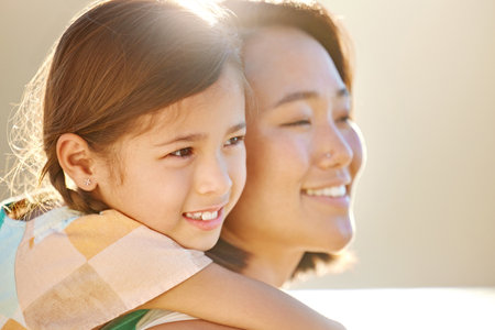 Spending time with her favourite little girl. Cropped portrait of an attractive young woman piggybacking her daughter on the beach.の写真素材