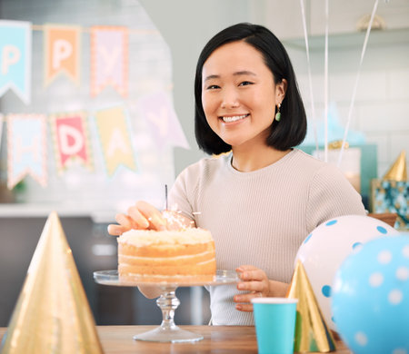 Birthdays are natures way of telling us, eat more cake. an young woman celebrating a birthday at home.の写真素材