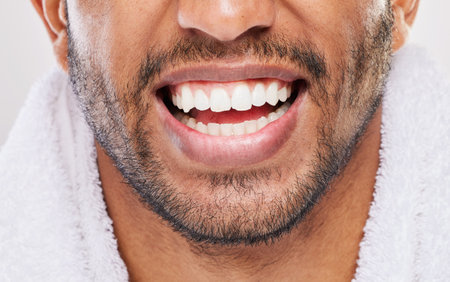The whitest smile. an unrecognizable man brushing his teeth against a grey background.の写真素材