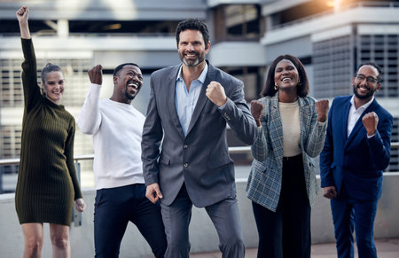 Our morning motivation. a group of businesspeople cheering against a city background.の写真素材
