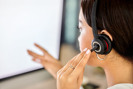 Updating your information in the system. a businesswoman using her PC while working in a call center.の写真素材