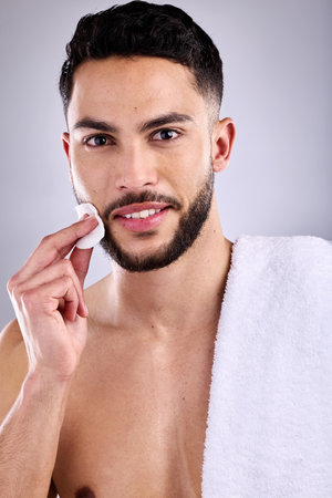 Dont just wash, care for your skin properly. a handsome young man cleaning his face with a cotton pad.の写真素材