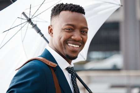catch me cheesing every day. a young businessman using an umbrella while walking through the city.の写真素材