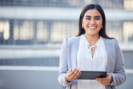 A quick breather for a non-stop grinder. a beautiful young. businesswoman using a digital tablet while standing outside.の写真素材