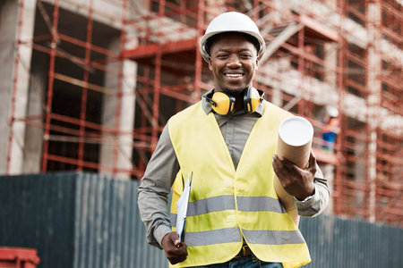 Building the city by hand. a male contractor holding a set of blue prints.