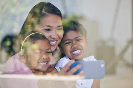 Youll always be my babies. a young woman taking selfies with her daughters.