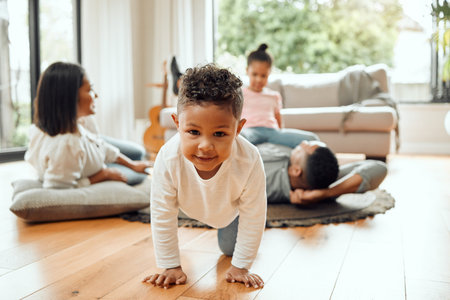 Miss me with those tickles. Portrait of an adorable little boy crawling while his family bonds on...