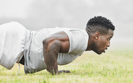 Putting those muscles to work. a handsome young male athlete doing pushups while exercising outside.