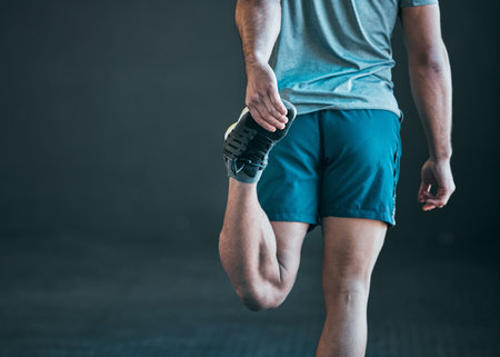 Back to his healthy best. Rearview shot of an unrecognizable young male athlete warming up against a...