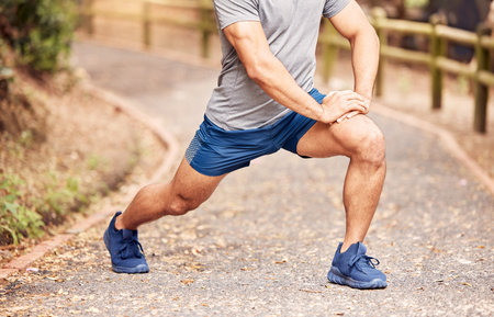 Only the best past the fitness test. an unrecognisable man stretching before her workout in nature.
