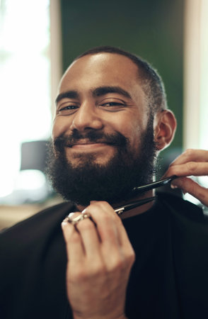 The world isnt ready for this handsome face. a handsome young man sitting and getting his beard...