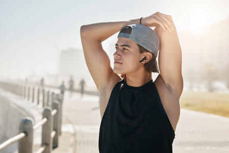 Exercise, fitness and runner stretching, listening to music and getting ready for cardio workout at a beach. Radio, health and workout with guy enjoying podcast, track and wellness audio streamingの写真素材