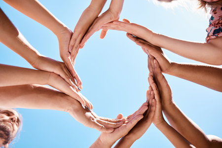 Hands, circle and community support hand sign of people and friends outdoor with a blue sky. Happy,...