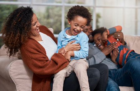 Its always fun to be around family. a happy family having fun together on a sofa at home.