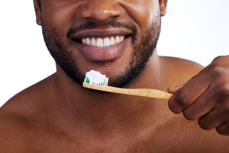 Pearly whites. Studio shot of an unrecognizable young man brushing his teeth against a white...