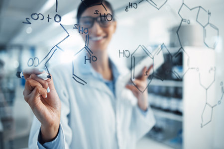 Nobody knows medicine like she does. a young scientist solving equations on a glass screen in a laboratory.の写真素材