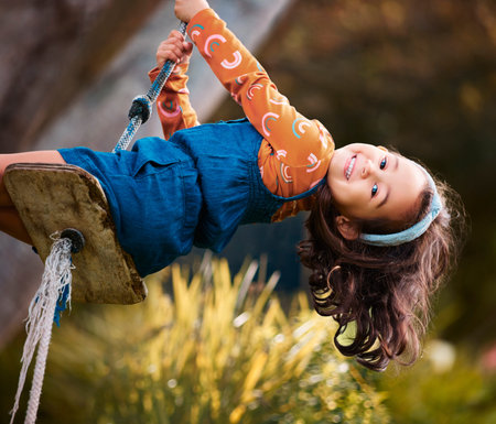 Choose happiness today. a little girl swinging in a park.の写真素材