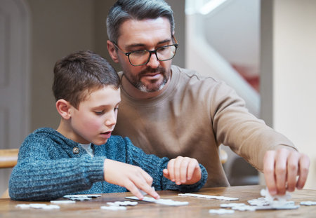 Quality time with you is all that matters. a father and son completing a puzzle together.