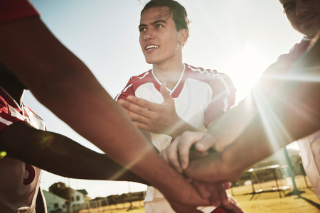 Hands stacked, soccer and team with support and motivation to win a game of sports on a field. Group...