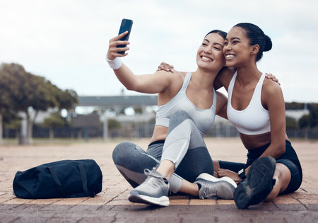 Friends, women and selfie for training in park, urban or outdoor while happy together in city. Smartphone, photo and girl with smile for exercise, wellness and workout for social media in Los Angelesの写真素材