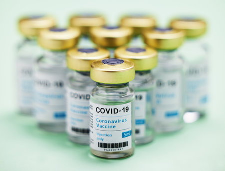 Anyone for a vaccine. Studio shot of vaccine tubes against a green background.の写真素材