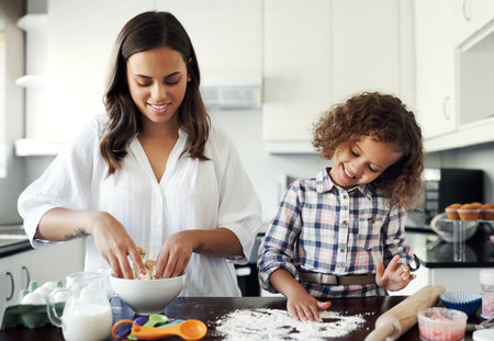 Mine doesnt look like mums. an adorable little girl baking with her mom at home.の写真素材