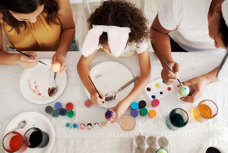 Family fun is all I want. a family painting Easter eggs together.の写真素材