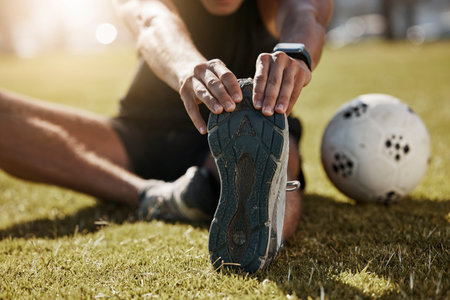 Stretching, foot and soccer man on field for sports training, exercise wellness or legs muscle health. Professional football person with sneakers or shoes for game warmup, workout outdoor on a pitchの写真素材