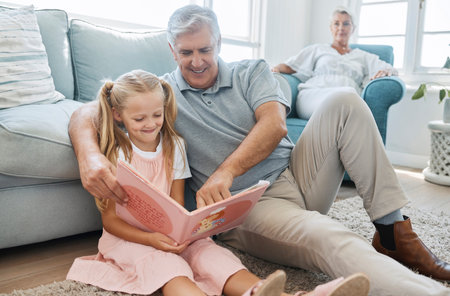 Book, child and grandfather reading a story for education, knowledge and happiness together on the...
