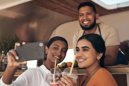 I think its a wonderful photo. two friends taking selfies while drinking smoothies.の写真素材